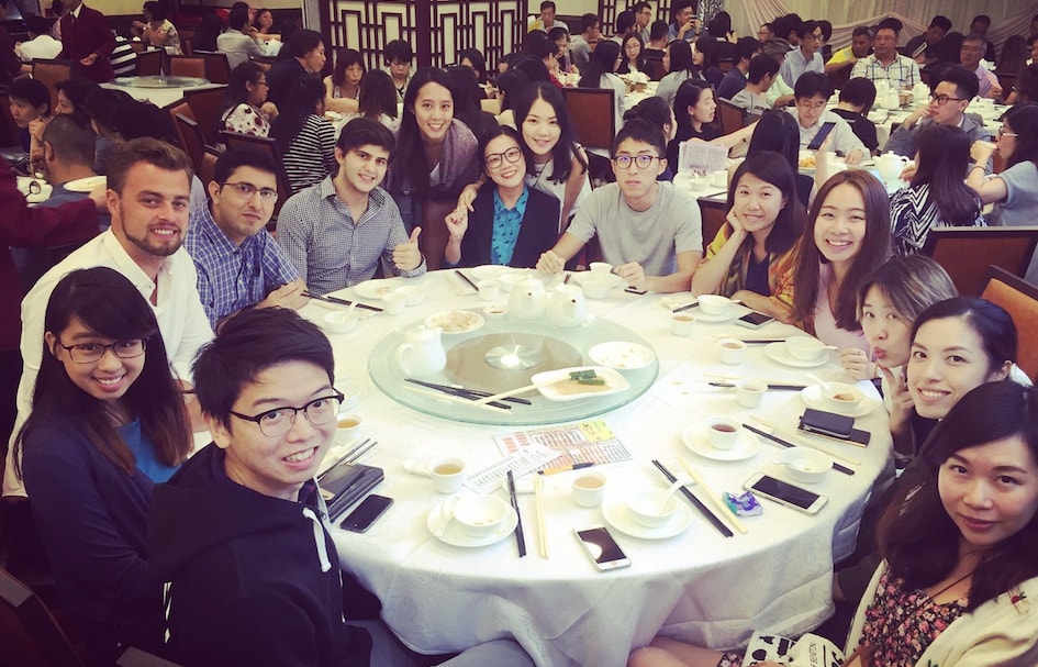 An award-winning group of people sitting around a table in Hong Kong.