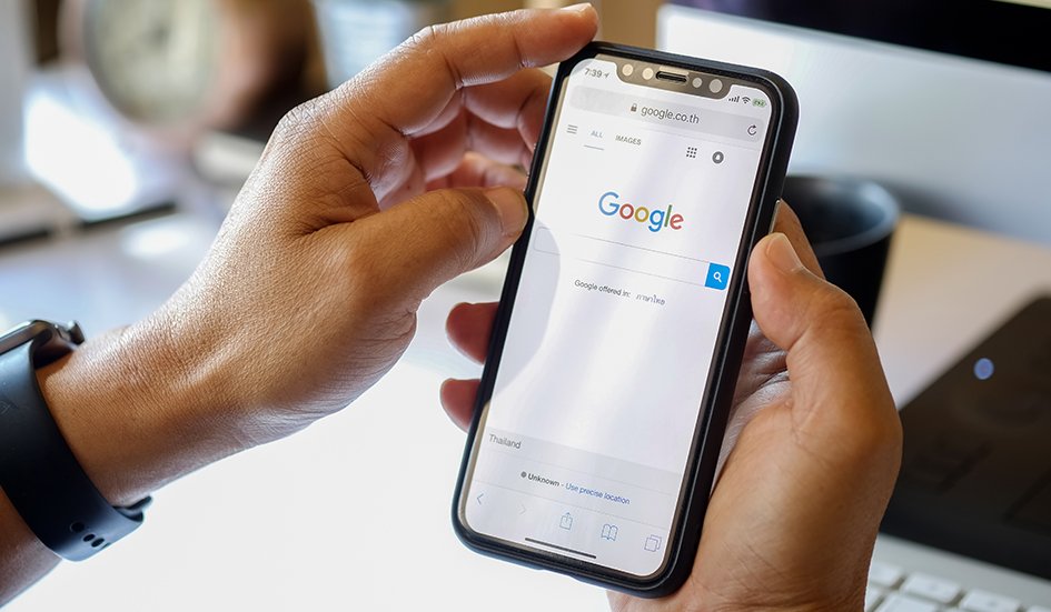 A person engaged in digital marketing is holding a phone displaying Google search results, emphasizing its relevance to SEO in Hong Kong.