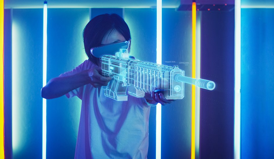 A man is holding a gun in front of an award-winning neon wall.